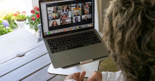 Laptop showing the Joan Garry team working remotely.