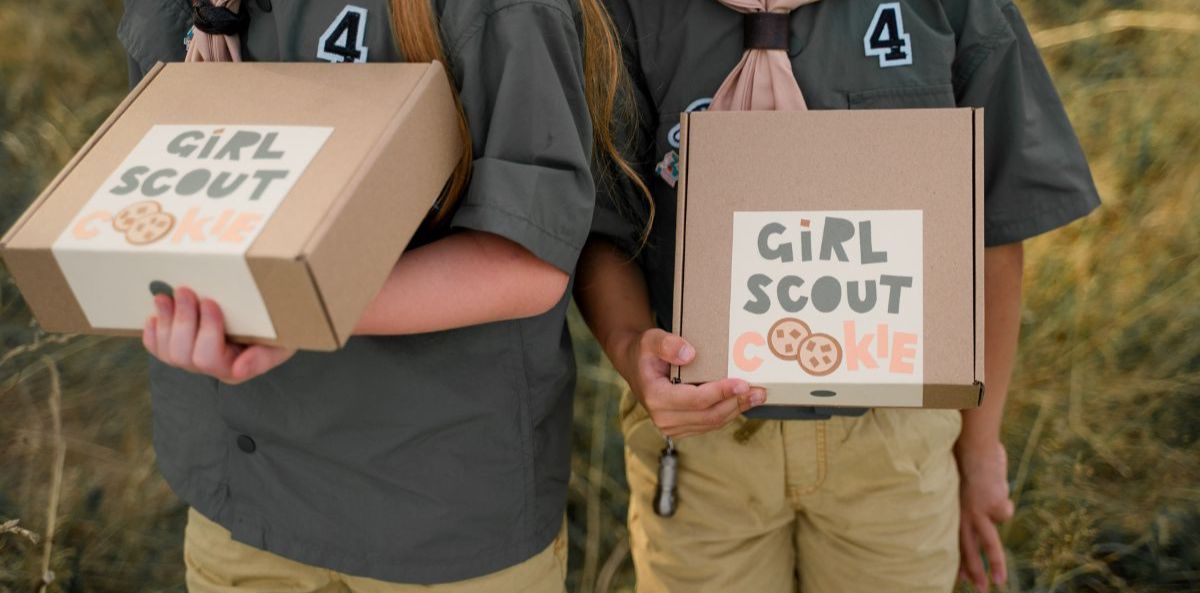 Two girls holding girls scout cookies boxes
