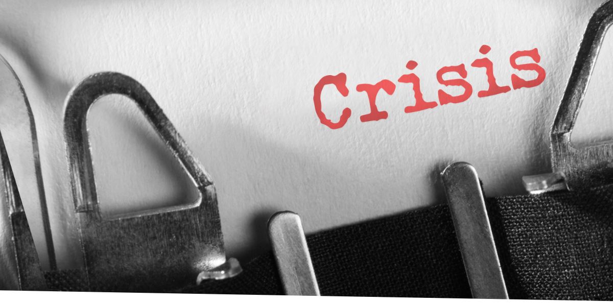 a close up shot of a type writer and piece of paper that says "Crisis" in orange. This represents a government shutdown.