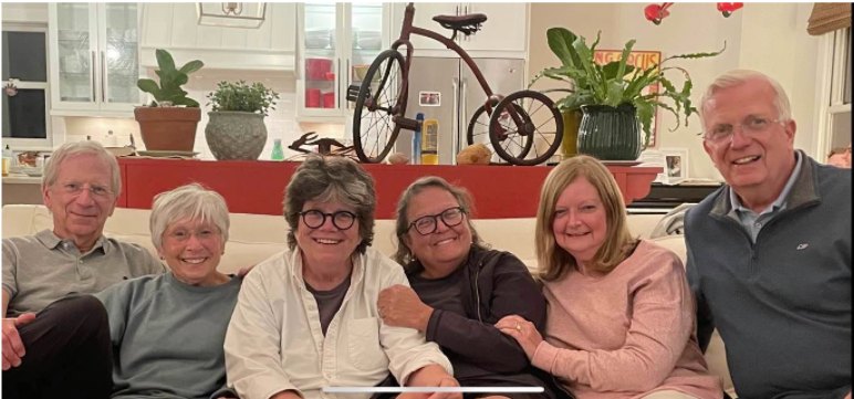 workplace self care - A family image of Joan and her wife Eileen in the middle of four members of Joan's family.